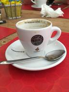 hot sweet coffee in a mug on a red table