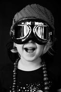 Black and white portrait of the cute girl child with hat and goggles