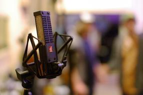 Close-up of the black, red and white ribbon microphone, at blurred background