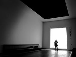 Black and white photo of the interior of the building with the person in light