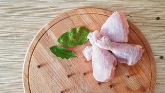 raw chicken legs on a wooden board