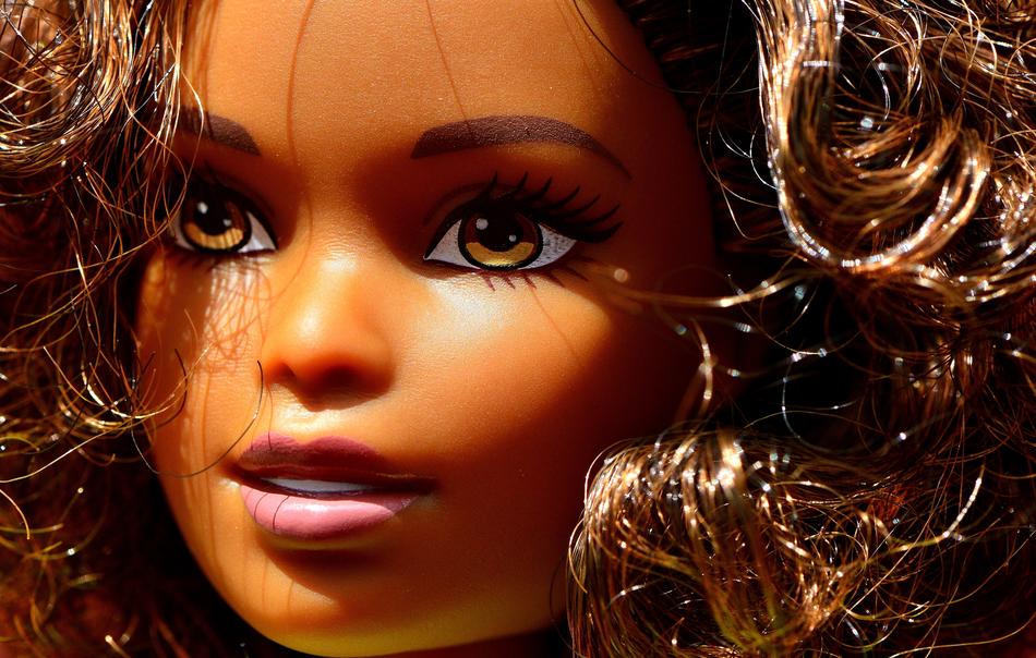Portrait of the shiny 'Barbie' girl with wavy hair, in light