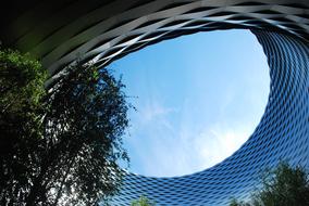 View of the glass building with green trees in Baselword, Basel, Switzerland