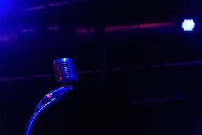 Close-up of the microphone on the stage with colorful lights