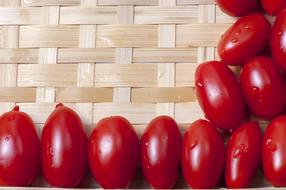 wet cherry tomatoes on wicker background