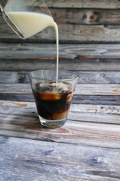 stream of milk flowing into the coffee