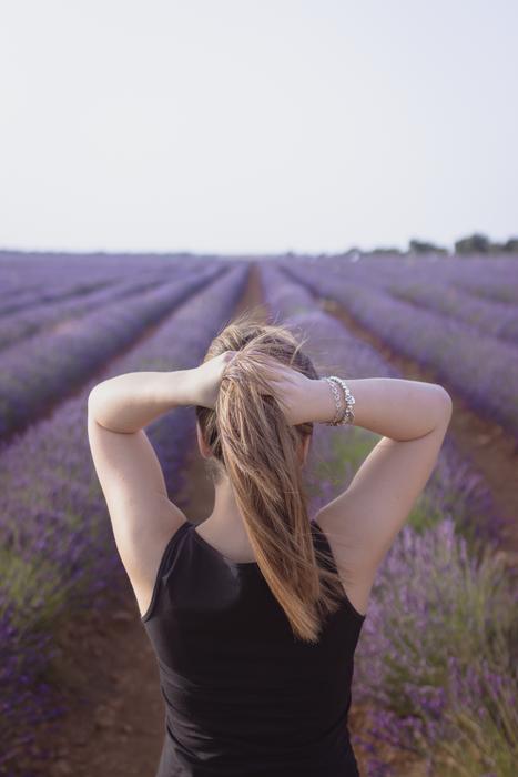 Back view with the girl among the beautiful lavender fields with flowers
