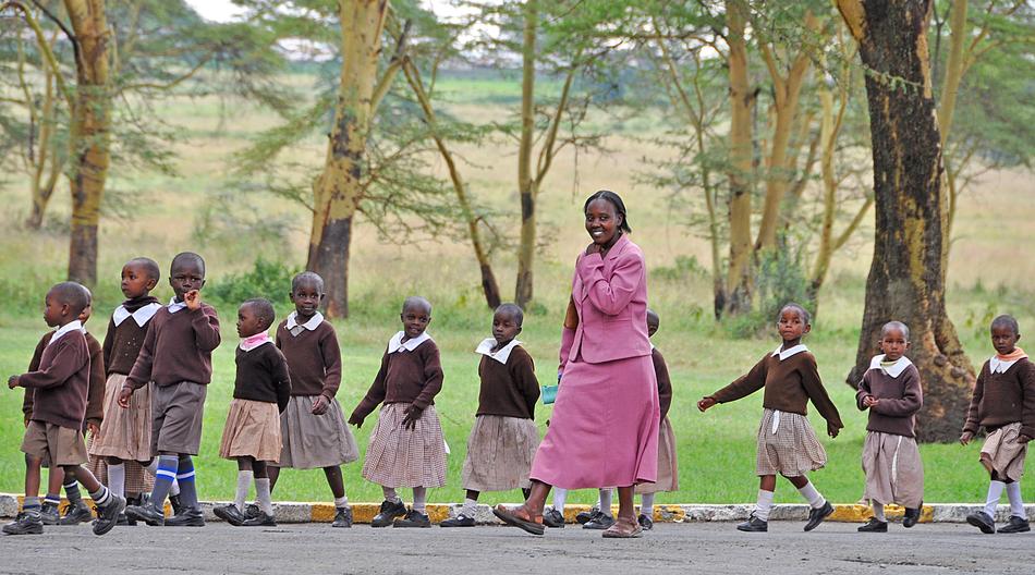 children with teacher on the road in kenya