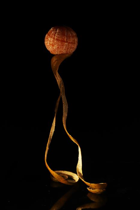 ripe tangerine with peel on a black background
