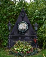 black grave with photo and flowers