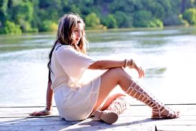 a girl in a white dress by the river