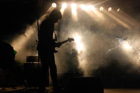 Guitarist on stage, silhouette at smoke, Concert