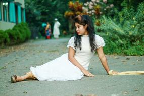 the girl in the white dress is sitting