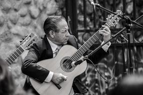 monochrome photo of a man playing a guitar