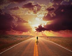 Silhouette of the man walking on the road, among the fields, at colorful sunset with clouds, clipart