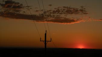 power lines in the background of clouds and red sky