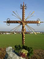 a golden cross in green meadows