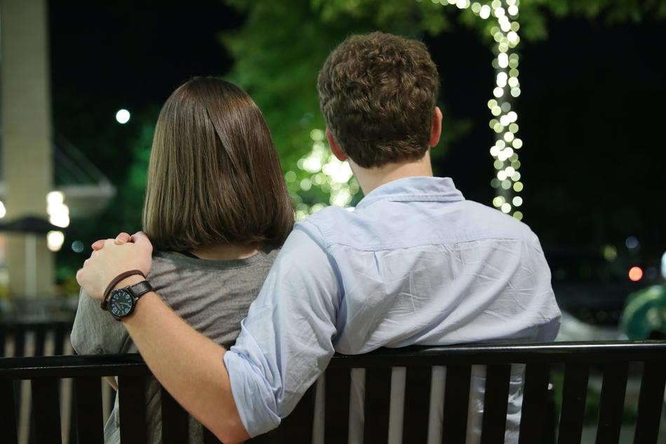 the girl and the guy are sitting with their backs