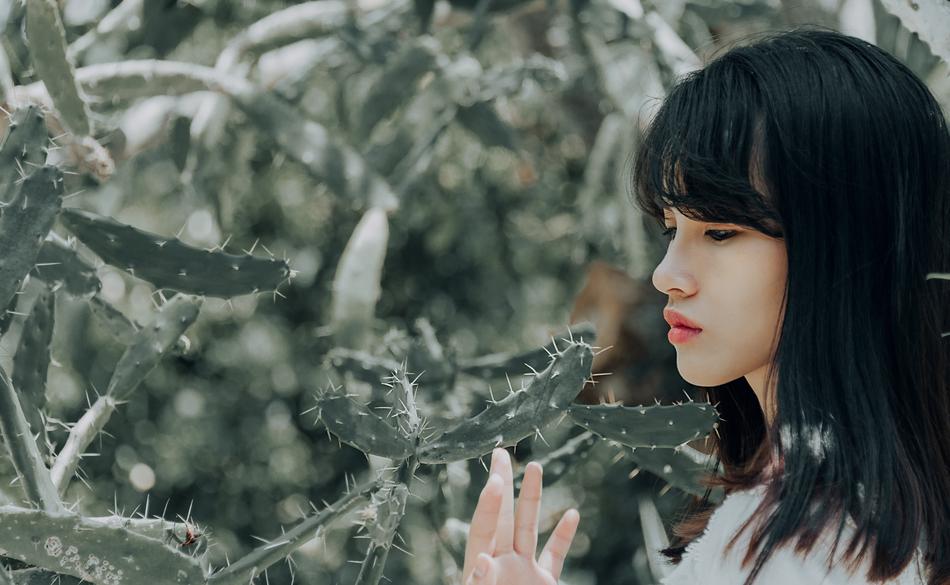 beautiful asian girl among thorny cacti