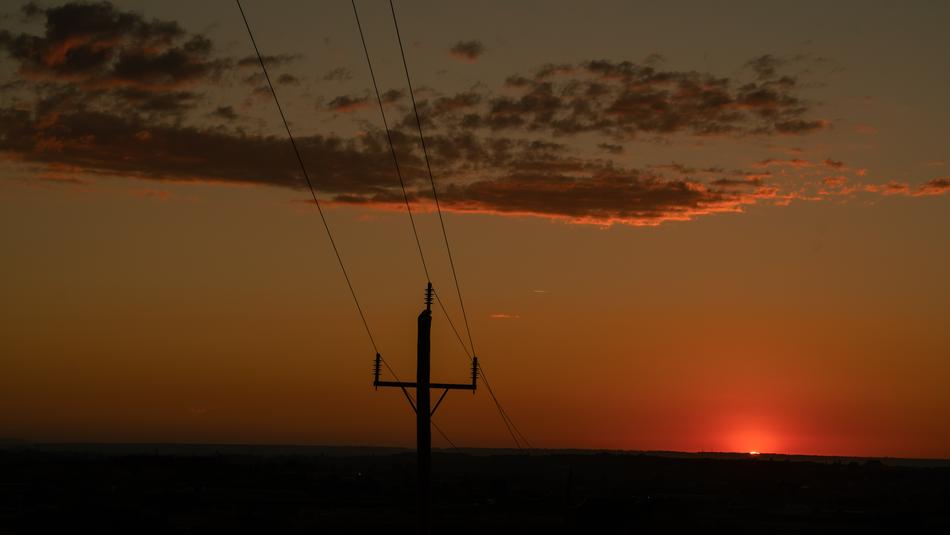 power lines in the background of clouds and red sky