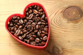 Roasted coffee beans in a red heart box