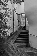 black and white photo of a staircase in an alley