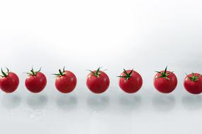 ripe tomatoes on a white background in the air