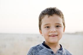 innocent boy smiling on the beach