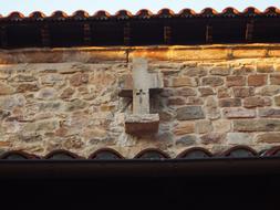 stone cross on the roof of the house