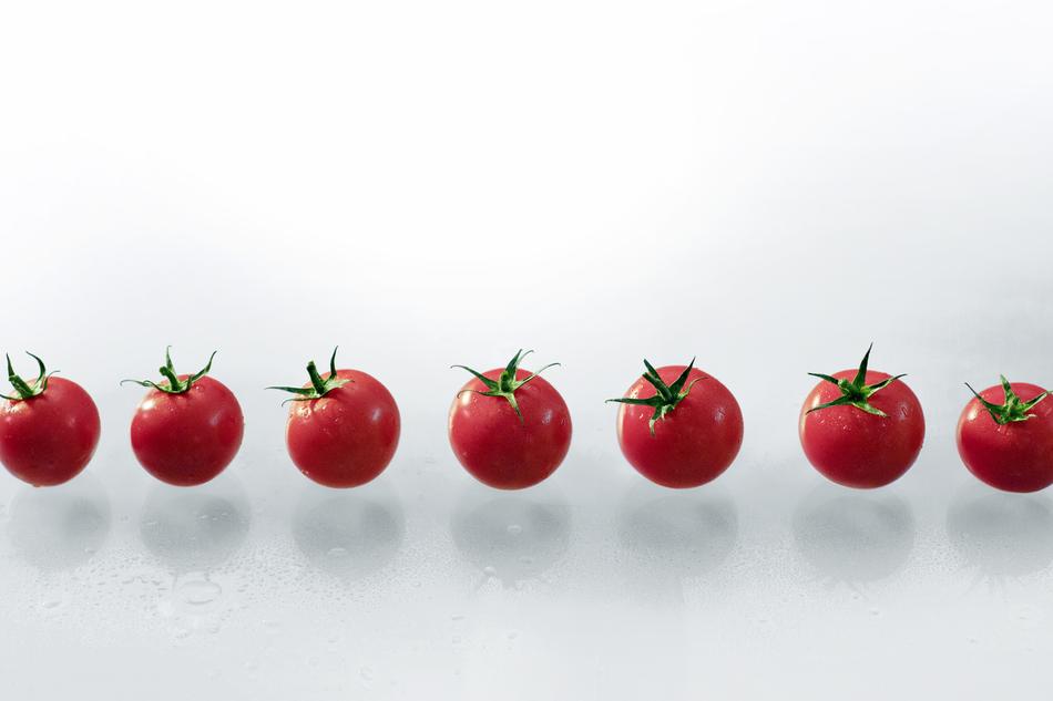 ripe tomatoes on a white background in the air