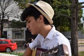 young man with guitar outside