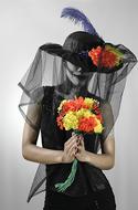 a girl in a black suit with a bouquet of flowers