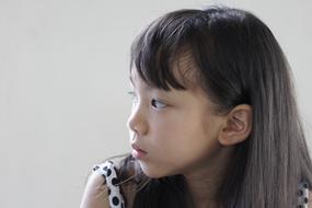 Asian girl looks carefully to the side