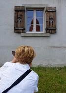 a woman in a white blouse at the window