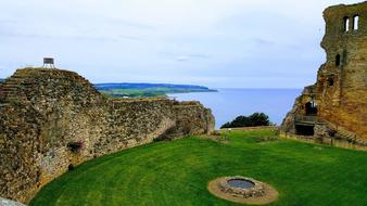 stone wall with a castle by the grass