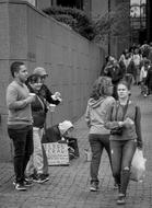 Black and white photo of the street with people begging for money