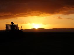 silhouette of man with coffee watching the sunset