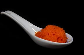 red caviar in a white spoon