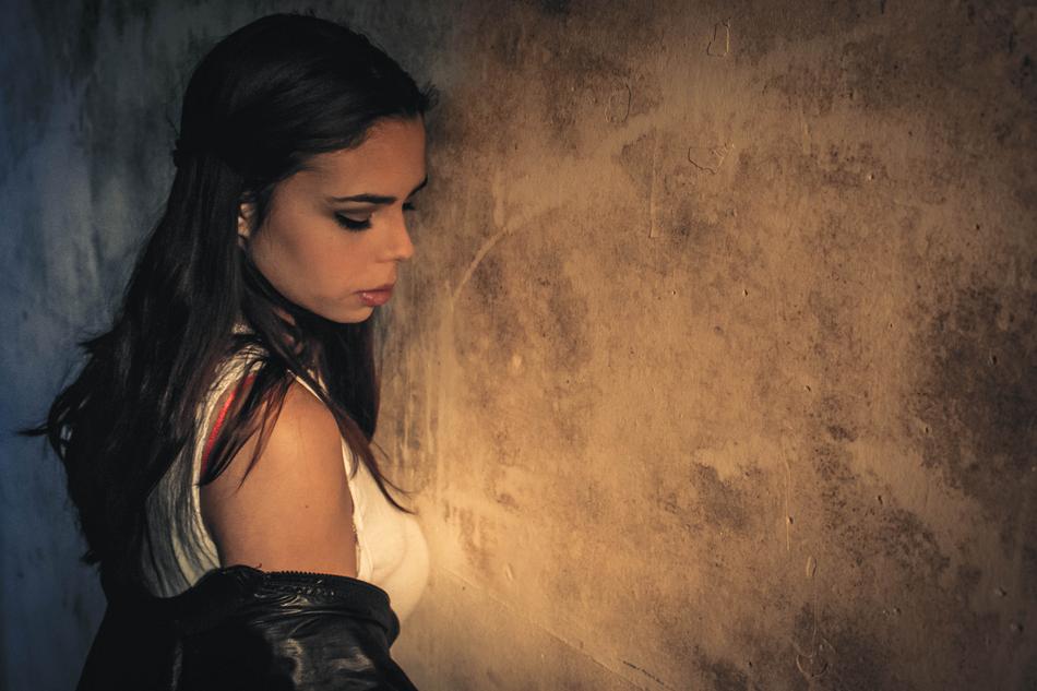 beautiful brunette stands against the wall