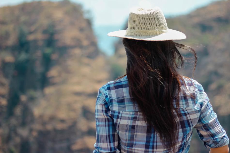 girl in a white hat on a background of mountains, blur