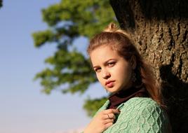 blonde in a green sweater on a wood background