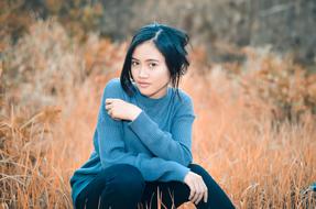 Asian girl posing among the colorful and beautiful grass and plants