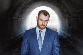 a man in a blue business suit in a tunnel