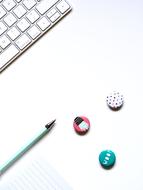 Colorful, patterned circles, pencil and paper, near the white keyboard of computer