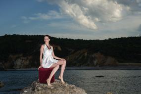 cute girl in a dress on a stone