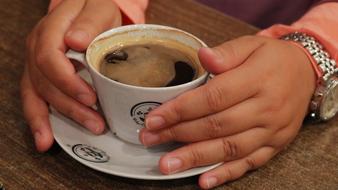 hands holding a mug of coffee