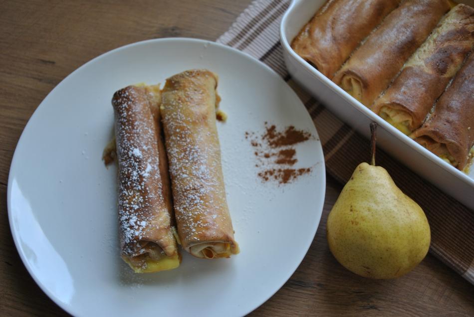 pancakes in sauce and pear on the table