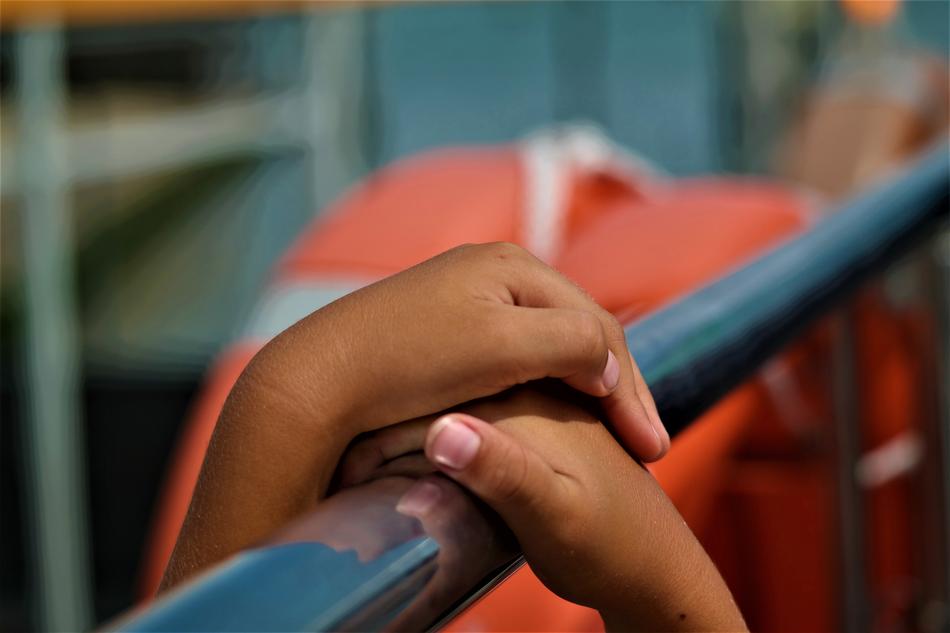 dark skin Child Hands on railing close up