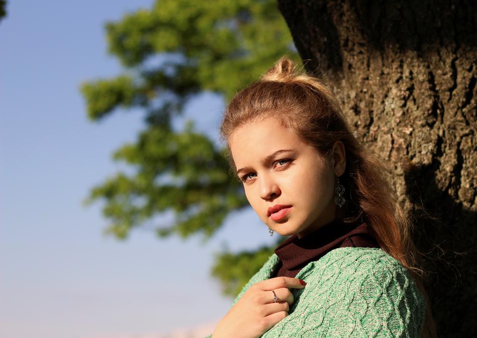blonde in a green sweater on a wood background
