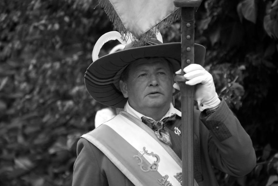 Black and white portrait of the standard-bearer with hat, near the plants, in Tyrol, Austria